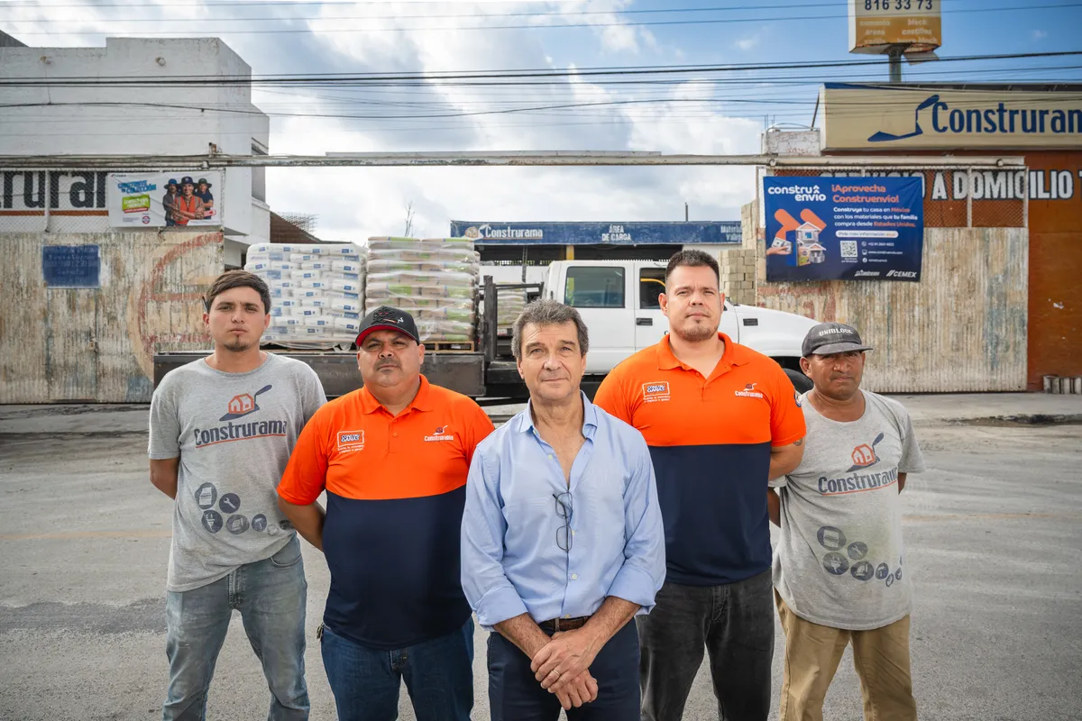 Equipo de un distribuidor de materiales de construcción frente a su tienda.